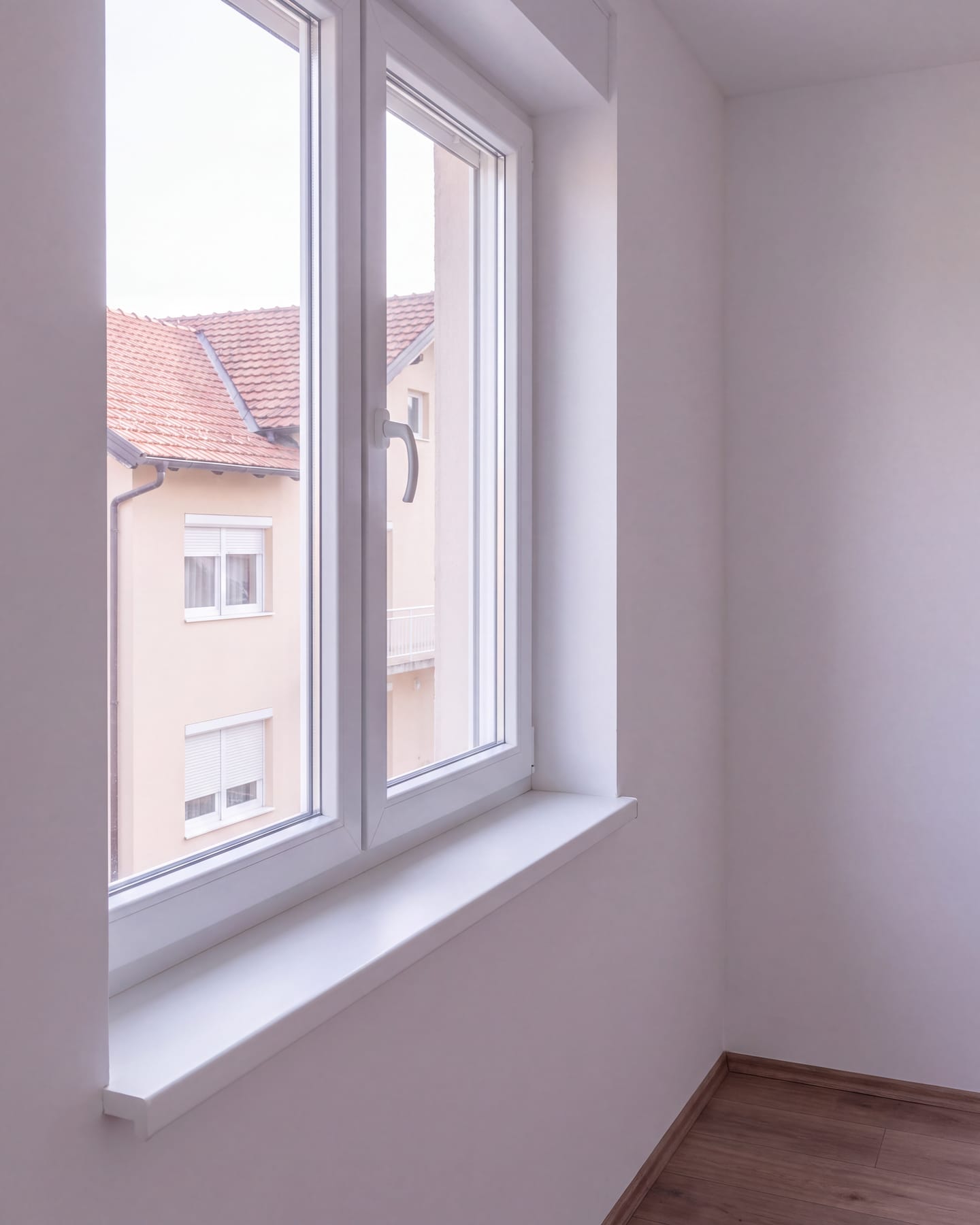 Detalj novog PVC prozora iznutra s obrađenom špaletom, bijelom klupčicom i ručkom prozora